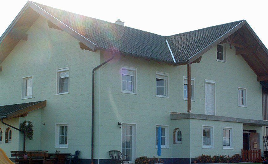 Grünes Haus mit einer Putzfassade von Zierer in der Farbe pastellgrün.