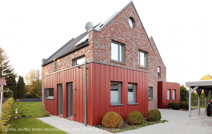 Rote Teilfassade am Anbau. Eternit Cedral Lap Boden-Deckel-Schalung.