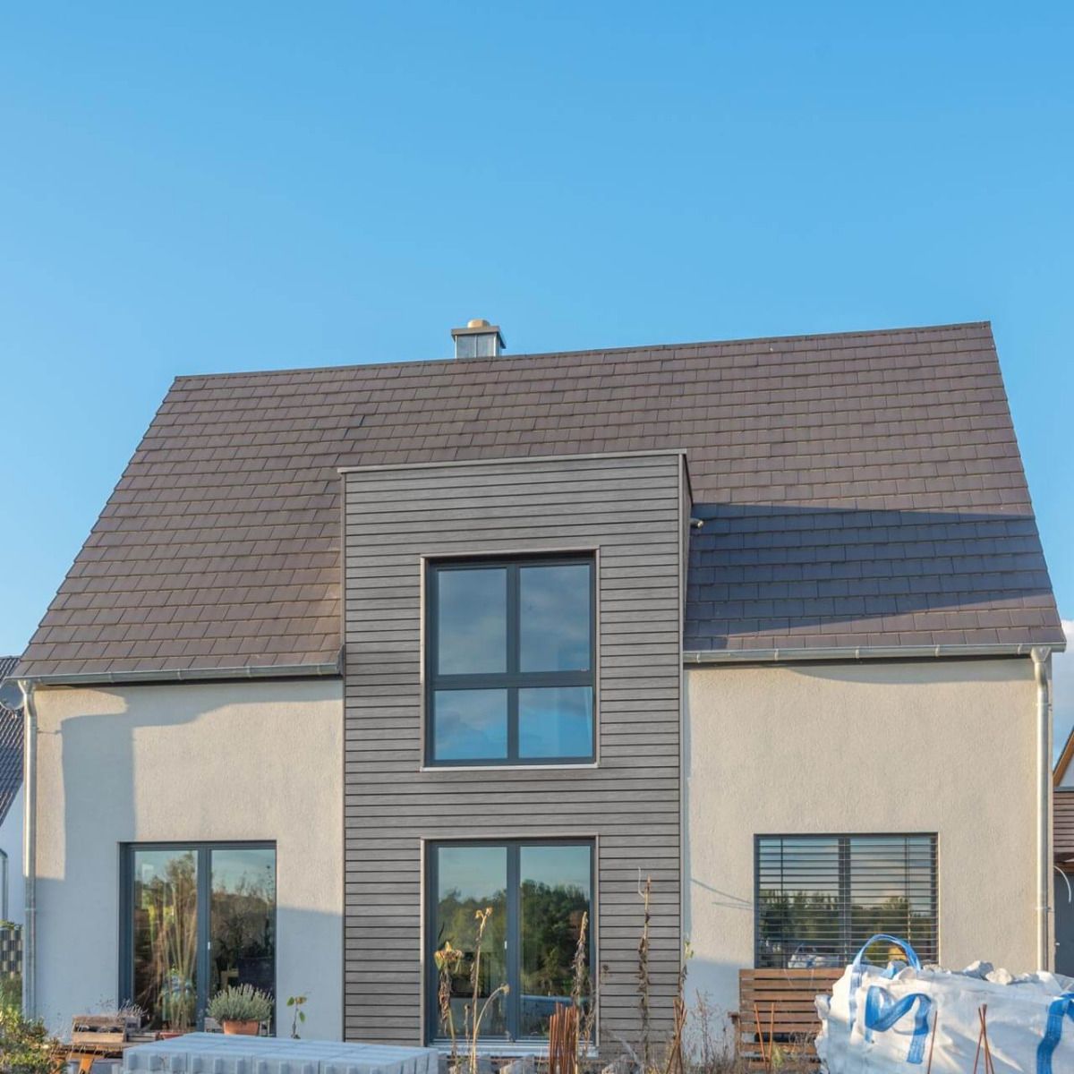 Ein Wohnhaus mit einer Fassadenverkleidung aus vinyPlus Quattro. Die authentisch wirkende Holzmaserung der QUATTRO Rhombusleisten schafft eine behagliche und zeitgemäße Stimmung für die Außenansicht des Hauses.