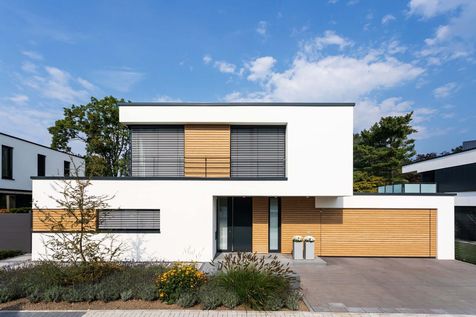 Modernes Einfamilienhaus im Bauhausstil. Die weiße Putzfassade wurde mit einer modernen und wartungsfreien Fassade in Rhombusoptik kombiniert. Die Rhombuspaneele vergrauen nicht.