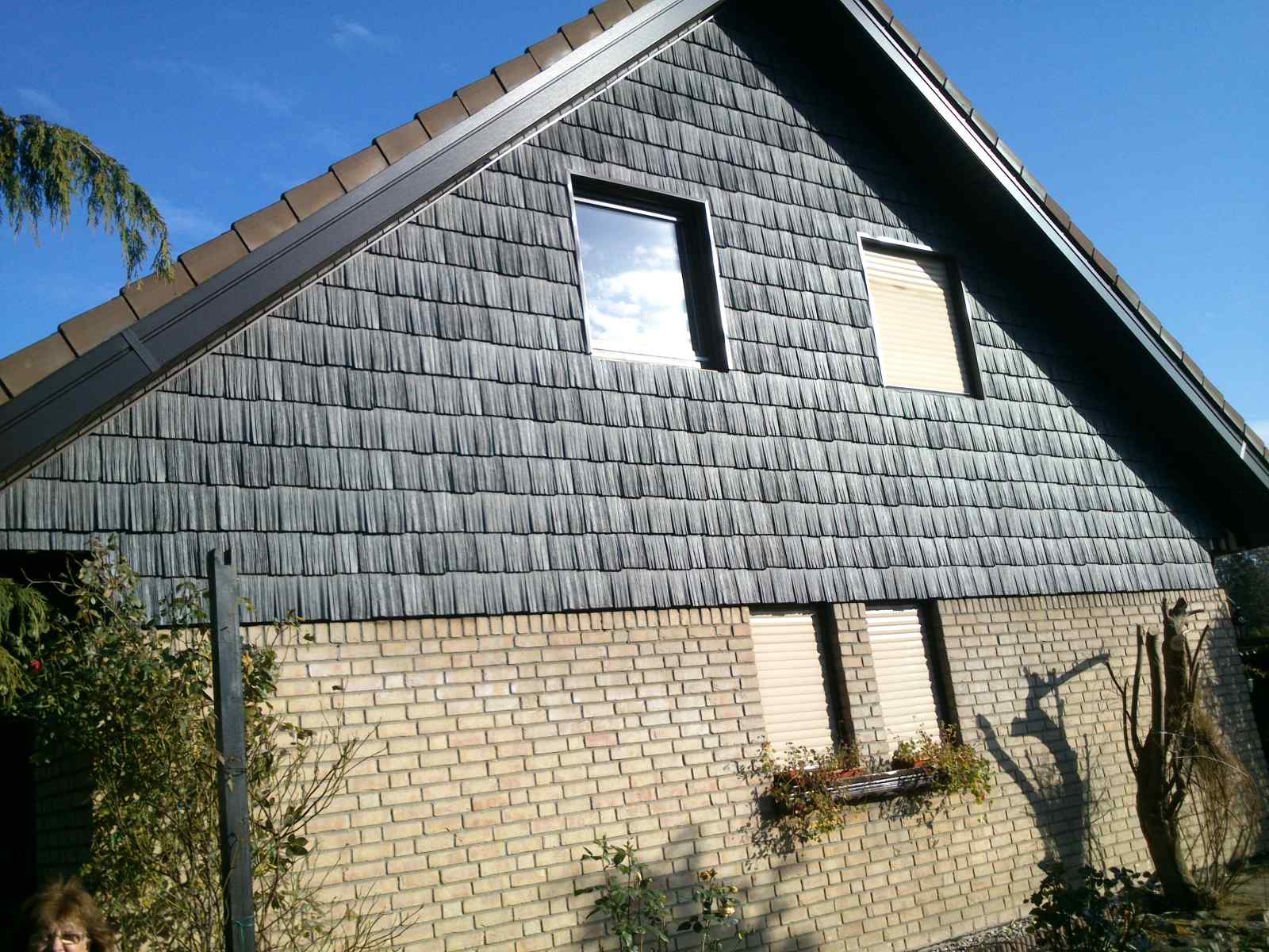 Holzschindelfassade am Giebel in dunkelbraun