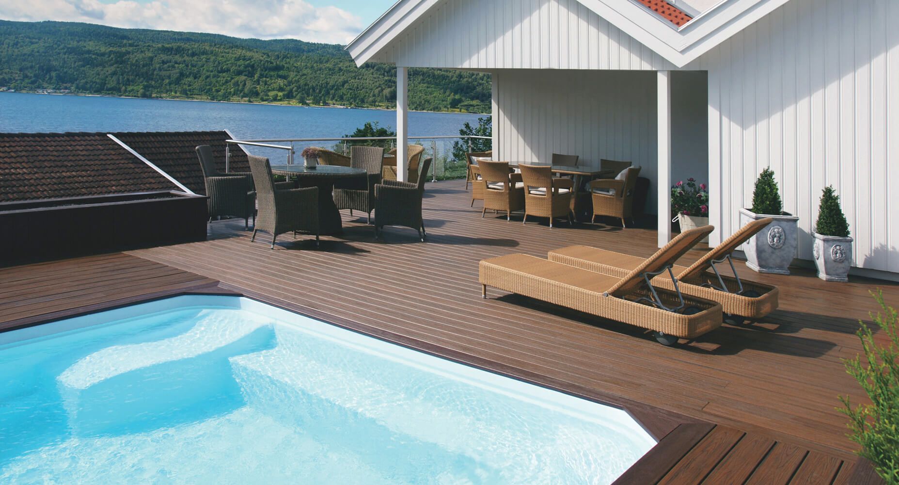 Große braune WPC Terrasse neben einem Pool.