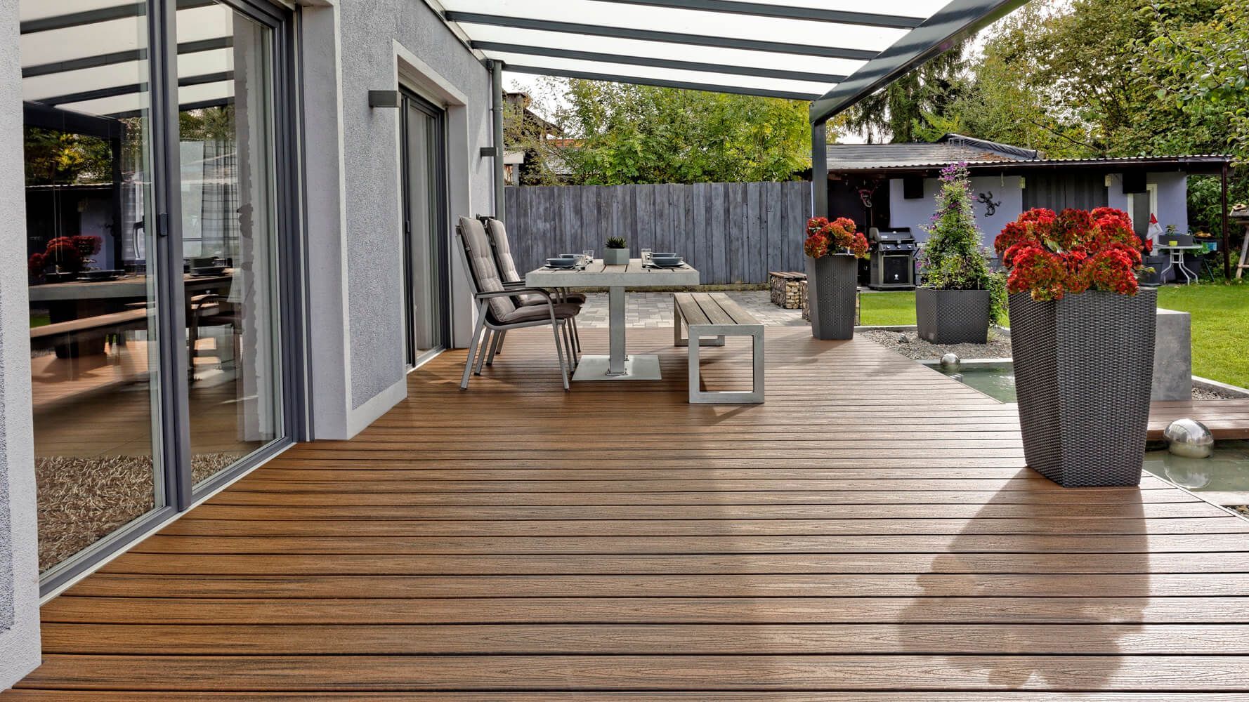Große braune Terrassenfläche mit einem Tisch und einer Bank aus WPC.