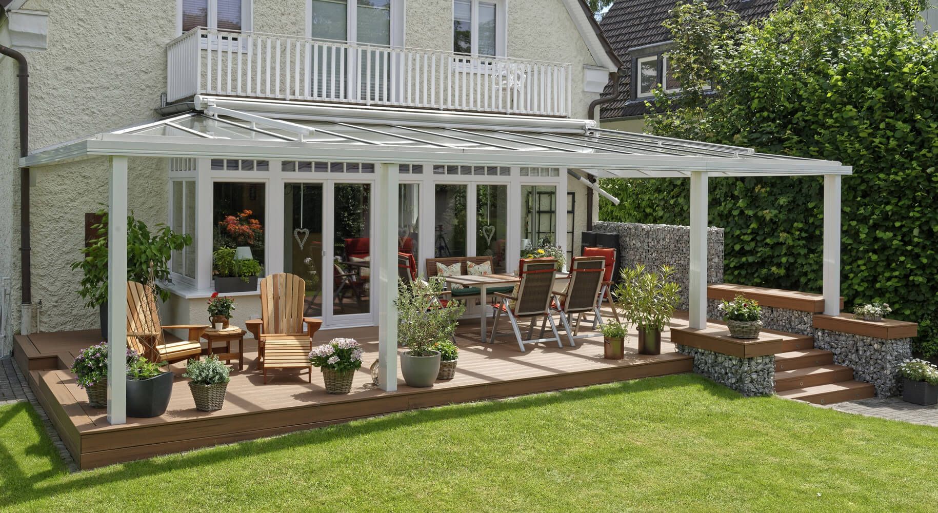 Große traditionelle Terrasse mit Glasdach und Gartenanschluss.
